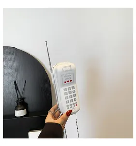 Détail d'un sac bandoulière blanc en forme de téléphone rétro avec pavé numérique