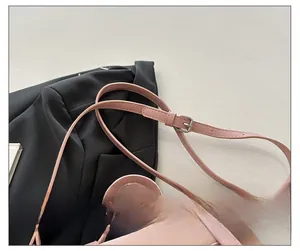 Detailed close-up of pink shoulder bag featuring an adjustable strap with silver buckle
