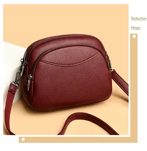 Detail view of burgundy PU leather round bag showing three-layer zipper compartments