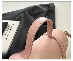 Close-up of pink leather tote bag handle with high-quality stitching and metal hardware