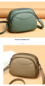 Detail view of round PU leather crossbody bags with dual zippers and pebble grain texture