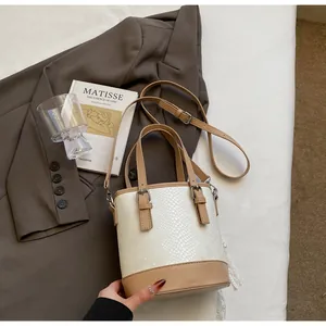 Detailansicht einer weißen Schlangenhaut-Beuteltasche mit kamelfarbenen Lederriemen