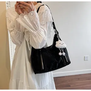 Détail du sac cabas noir avec texture froncée et breloque en peluche nuage blanc