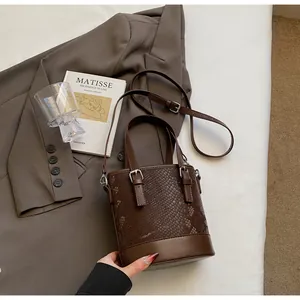 Detailansicht der braunen Bucket-Bag mit Schlangenprägung und metallischen Schnallen