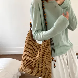 Brown crochet hobo bag with hollow mesh design and vintage wooden beaded shoulder strap