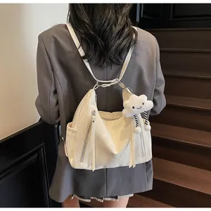 Détail du sac cabas crème avec fermeture éclair métallique et breloque nuage en peluche