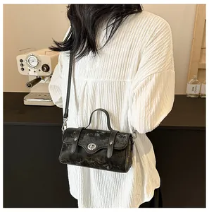 Close-up of vintage black textured leather crossbody bag with silver twist lock and strap