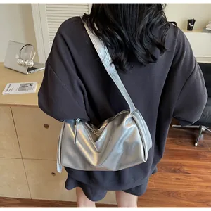 Detail einer silbernen Schultertasche mit metallischem Finish und weicher Faltenstruktur