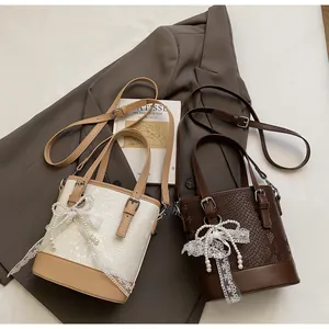 Nahaufnahme von Vintage-Eimertaschen mit Perlen, Spitzenbögen und Präge-Textur