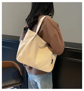 Dettaglio della borsa tote in tela con tasca laterale ed etichetta logo MIDOLAI