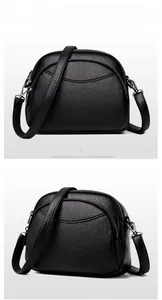 Detail of black lychee grain PU leather crossbody bag with triple zipper compartments