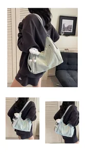 Vue détaillée du sac cabas vert menthe avec poches zippées et breloque en peluche douce
