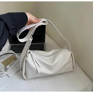 Nahaufnahme der cremefarbenen Zylindertasche aus weichem Leder mit breitem Schultergurt
