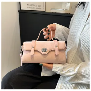 Detail of pink faux suede crossbody bag with silver twist lock and minimalist design