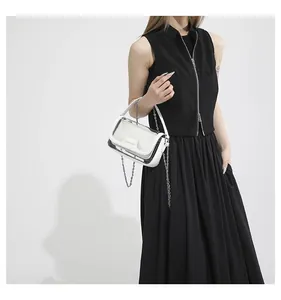 Detail einer transparenten PVC-Gelee-Tasche mit weißem Lederbesatz und Silberkette