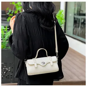 Detail showing the cream crossbody bag worn on back with adjustable strap and silver buckle