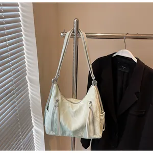 Détail du sac fourre-tout crème plissé avec deux poches zippées et longues tirettes