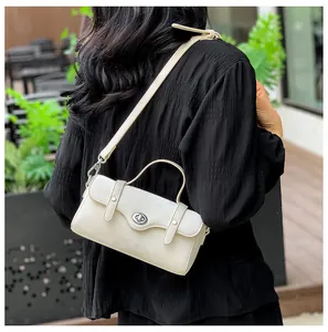 Detail of off-white leather shoulder bag with silver turn-lock and adjustable strap