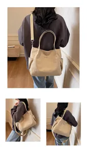 Dettaglio della borsa tote in tela beige con tracolla rimovibile e tasche laterali