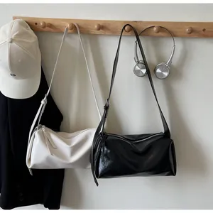 Minimalistische zylindrische Umhängetaschen in Beige und Schwarz mit Lederriemen