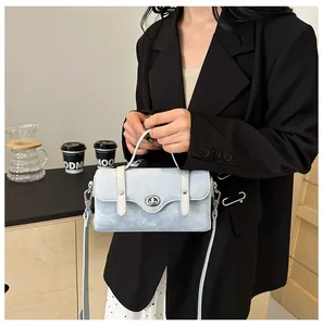 Detail of light blue crossbody bag with marble texture and silver twist lock on a model