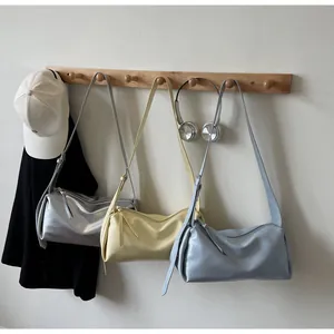Detailansicht minimalistischer weicher Unterarmtaschen in Silber, Gelb und Blau