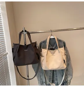 Dettaglio di borse tote in tela color caffè e crema con tracolle e tasche laterali