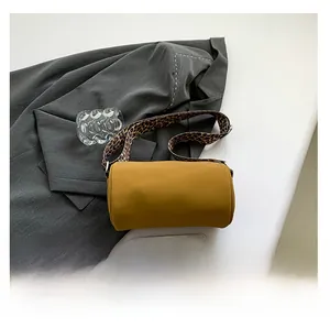 Dettaglio della borsa a cilindro gialla con tracolla larga con stampa leopardata alla moda