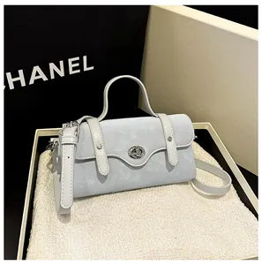 Detail view of light blue crossbody bag with silver twist lock in a gift box