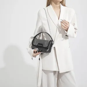 Schicke schwarze transparente PVC-Umhängetasche mit Silberkette an einem Model