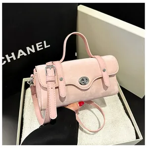 Close-up of pink velvet crossbody bag featuring silver turn-lock and leather straps