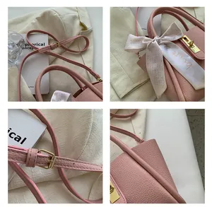 Détails macro du sac en cuir rose avec fermoir doré et poignée ornée d'un foulard en soie