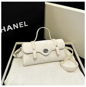 Close-up of white minimalist crossbody bag with silver twist-lock and matte suede texture