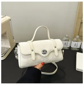 Detailed view of off-white crossbody bag featuring a silver rotary lock and textured flap