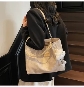 Detailed close-up of beige tote bag with floral texture and soft cloud charm