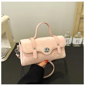 Detail of pink velvet textured handbag with silver metal twist lock and rivet straps