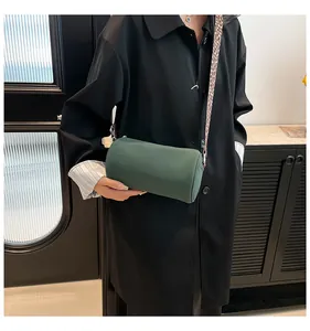 Dettaglio della borsa a cilindro verde con tracolla larga alla moda a stampa leopardata