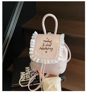 Dettaglio dello zaino mini rosa con bordo a volant bianchi e ricamo sulla parte frontale