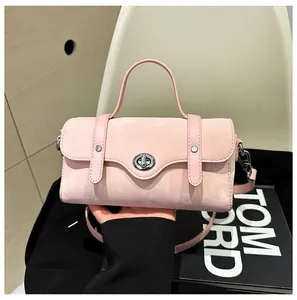 Detail of pink suede handbag featuring a scalloped flap and silver twist-lock closure