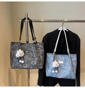 Detail of floral tote bags with cloud charms, showing textured canvas and leather labels