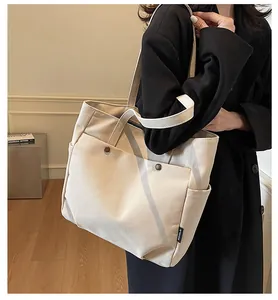 Detail of minimalist cream canvas tote bag with vintage buttons and side pocket