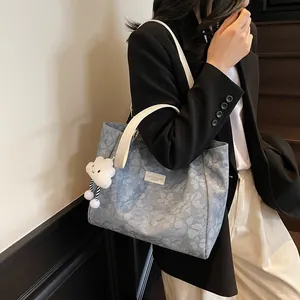 Blue floral tote bag with white straps and cute cloud charm for casual fashion
