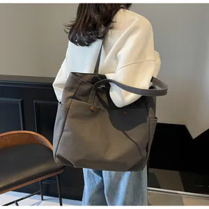 Side view of charcoal grey large canvas tote bag with side pockets and button detail