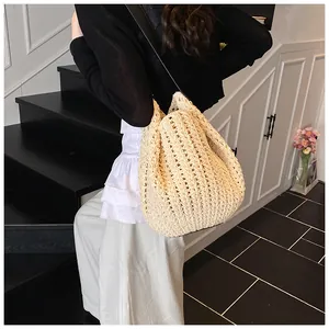Detailed macro of the woven geometric texture and hollow pattern on a cream bucket bag