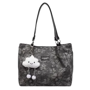 Deep grey clover embossed tote bag with black leather straps and cloud charm accessory