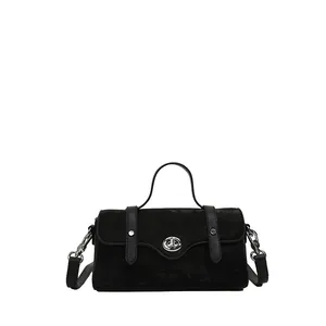 Classic black suede crossbody bag with silver turn-lock and top handle on white background