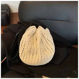 Detail of creamy white hollow out woven bag with premium black leather shoulder strap