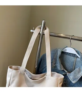 Close-up of thick comfortable shoulder straps on cream canvas tote bag with clean stitching
