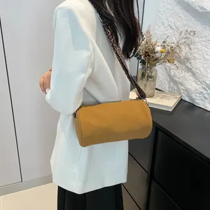 Elegante borsa a cilindro gialla con ampia tracolla leopardata indossata con un blazer