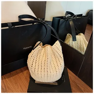 Close-up of beige crochet bucket bag featuring hollow woven texture and leather strap
